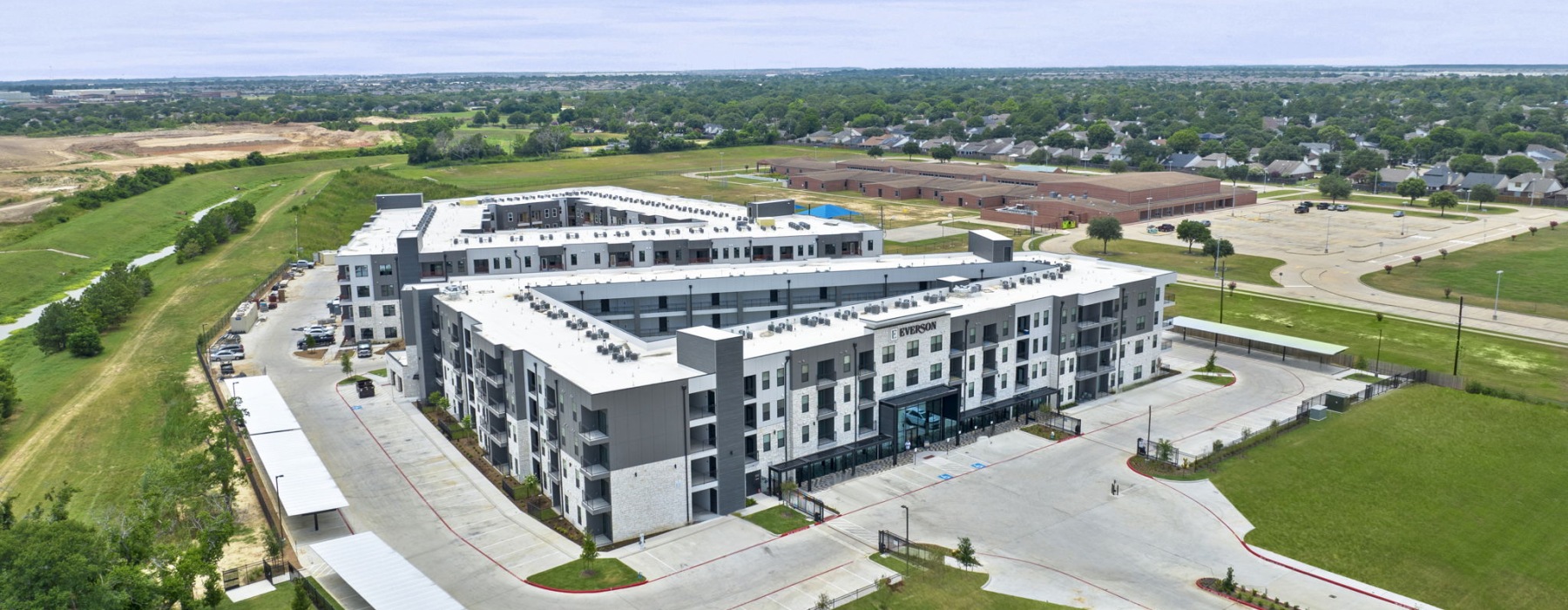The Everson Building has a large parking lot and quiet area surrounded by grass.